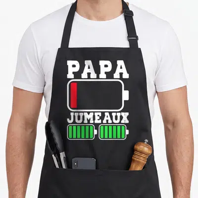 Tablier de cuisine noir avec une illustration de batterie Papa vide et deux batteries jumeaux pleines en vert.