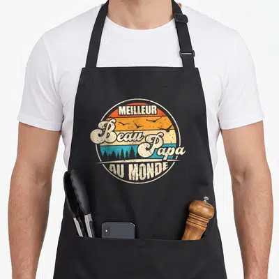Tablier de cuisine noir avec un motif circulaire vintage affichant Meilleur Beau Papa au Monde sur fond rayé orange et bleu.