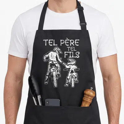 Tablier de cuisine noir avec illustration blanche de deux pilotes de moto cross et le texte Tel Père Tel Fils