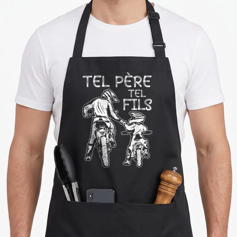 Tablier de cuisine noir avec illustration blanche de deux pilotes de moto cross et le texte Tel Père Tel Fils