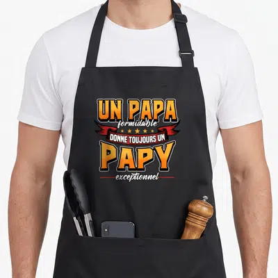 Tablier de cuisine noir avec inscription Un papa formidable donne toujours un papy exceptionnel en orange et blanc sur fond de ruban rouge.