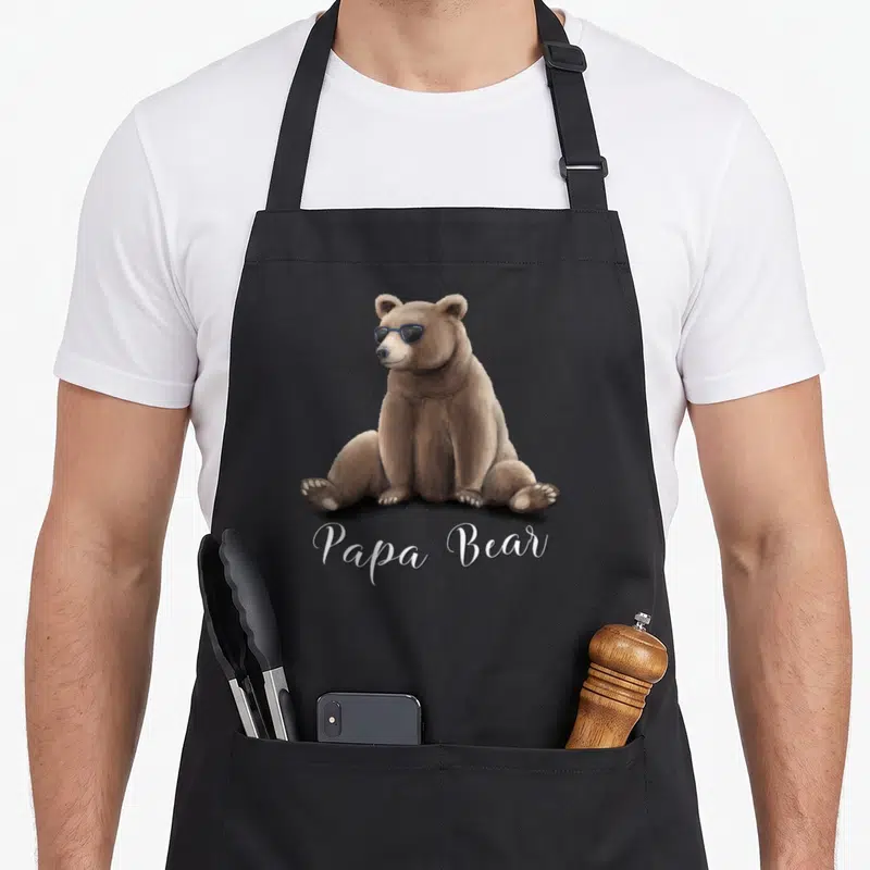 Tablier de cuisine noir avec ours grizzly assis en lunettes noires et texte Papa Bear en blanc.
