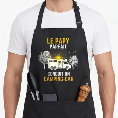 Tablier de cuisine noir avec illustration de camping-car blanc, arbres et texte Le papy parfait conduit un camping-car en jaune et blanc.