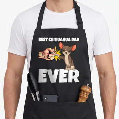Tablier de cuisine noir avec illustration d'un chihuahua et d'une main effectuant un poing-contre-poing humoristique.