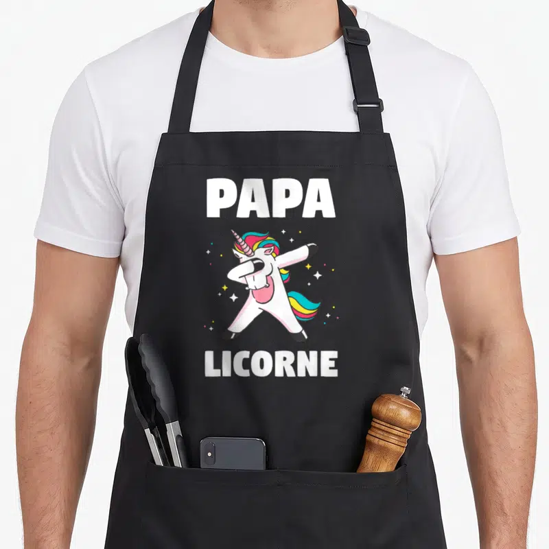 Tablier de cuisine noir avec une licorne blanche en train de faire le dab et le texte Papa Licorne en blanc.