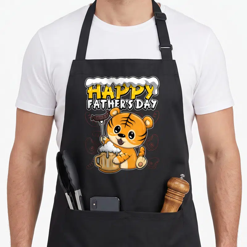 Tablier de cuisine noir avec un tigre orange tenant une bière et une saucisse sous le texte Happy Father's Day.