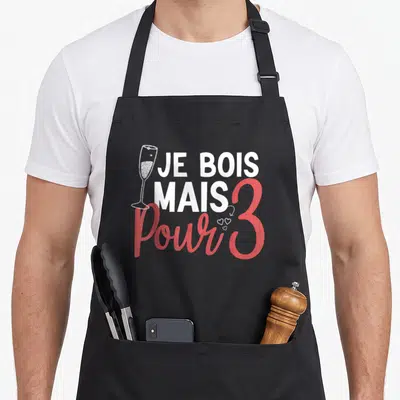 Tablier de cuisine noir avec texte blanc et rose Je bois mais pour trois et illustration de verre à champagne.