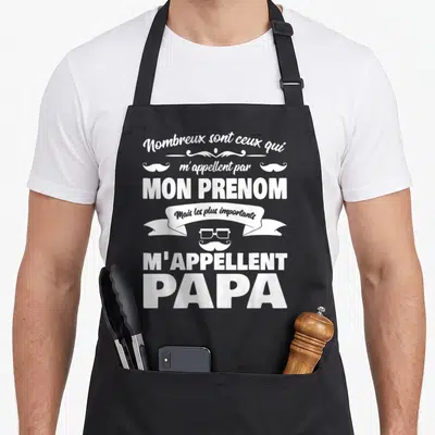 Tablier de cuisine noir avec inscription blanche Mon Prénom C'est M'Appellent Papa et icône moustache lunettes.