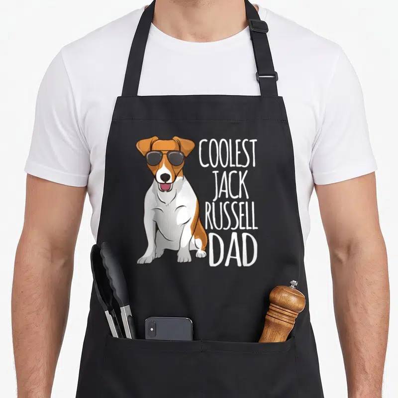 Tablier de cuisine noir avec un Jack Russell Terrier aux lunettes noires et le texte Coolest Jack Russell Dad en blanc.