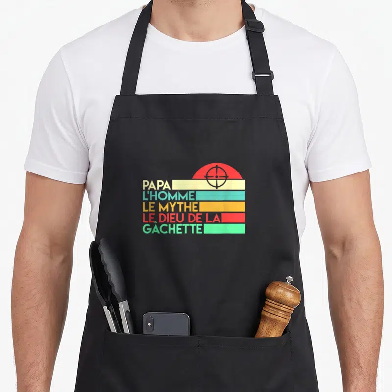 Tablier de cuisine noir avec motif retro couleur affichant Papa l'homme le mythe dieu de la gachette et une cible rouge.