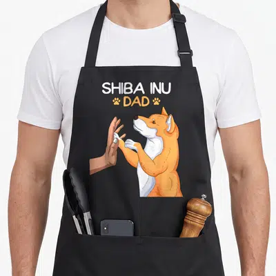 Tablier de cuisine noir avec un Shiba Inu faisant un high five et le texte SHIBA INU DAD.