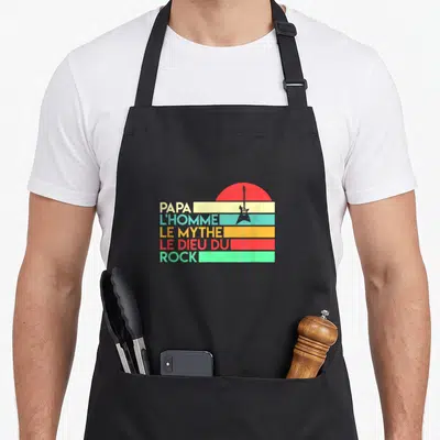 Tablier de cuisine noir avec inscription Papa l'homme le mythe le dieu du rock et une guitare sur fond rayé rétro.