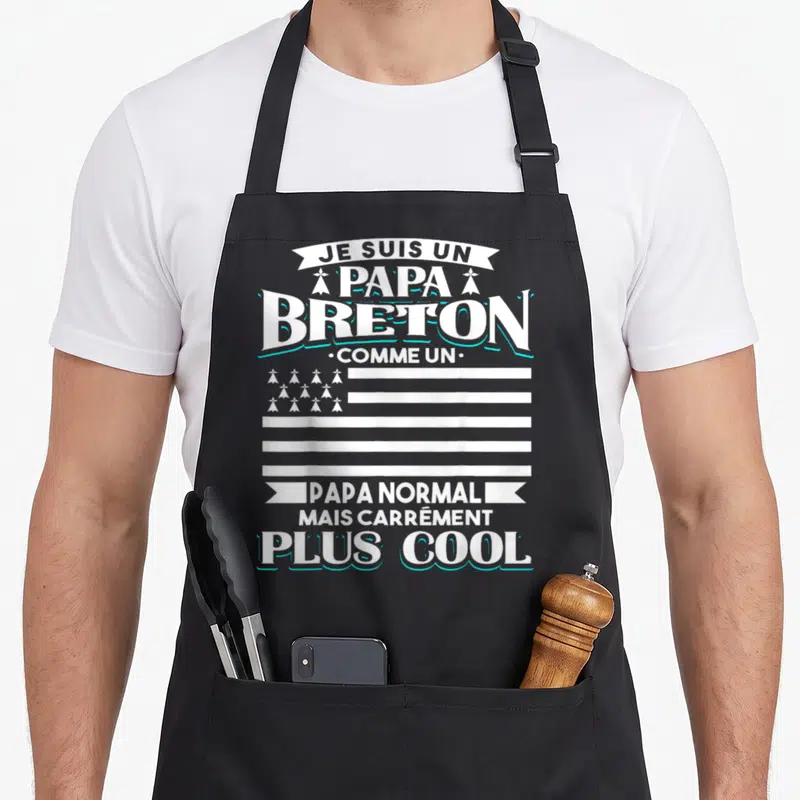 Tablier de cuisine noir avec l'inscription Je suis un papa breton comme un papa normal mais carrément plus cool en blanc et turquoise.