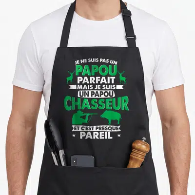 Tablier de cuisine noir avec inscription humoristique sur le papou chasseur et silhouettes de cerfs et sangliers verts.