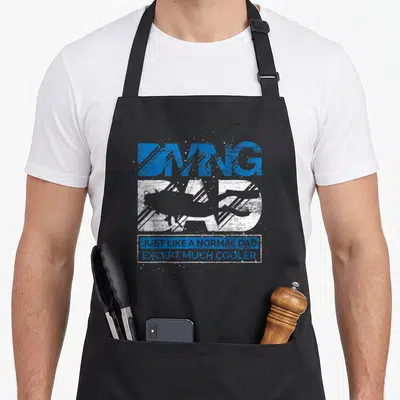 Tablier de cuisine noir avec silhouette de plongeur et texte Just Like A Normal Dad Except Much Cooler en bleu et blanc.