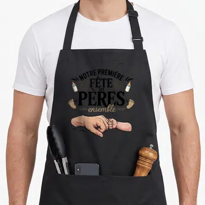 Tablier de cuisine noir avec illustration poignée de main papa et bébé, biberons et texte fete des peres.
