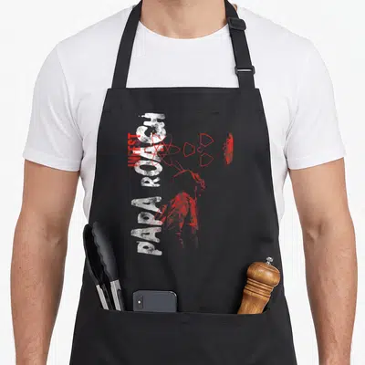 Tablier de cuisine noir avec inscription Papa Roach Infest Tightrope et symboles atomiques rouges sur fond gris uni.