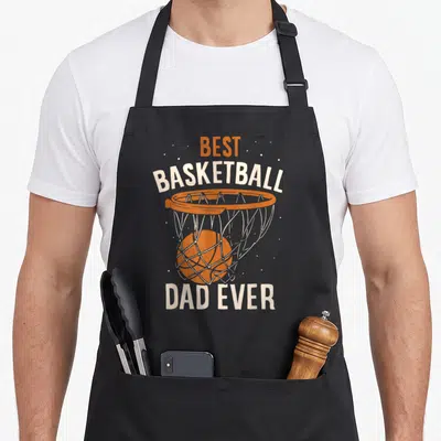 Tablier de cuisine noir avec illustration d'un panier de basket orange et texte Best Basketball Dad Ever en blanc et orange.