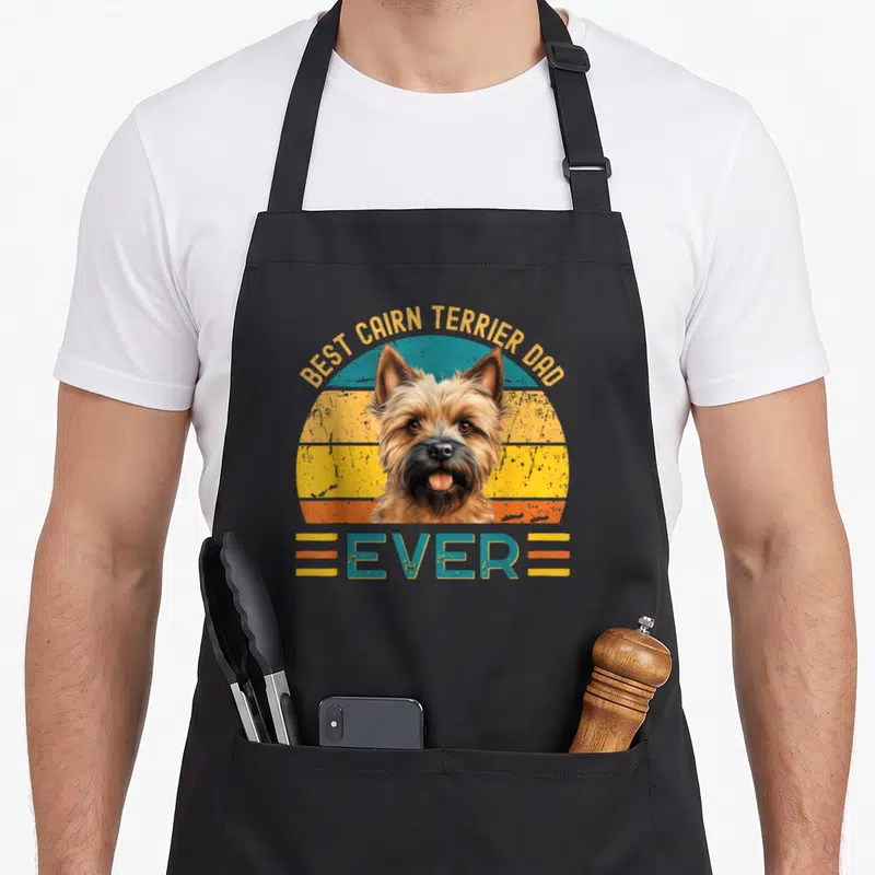 Tablier de cuisine noir avec illustration rétro d'un chien et texte jaune et bleu.