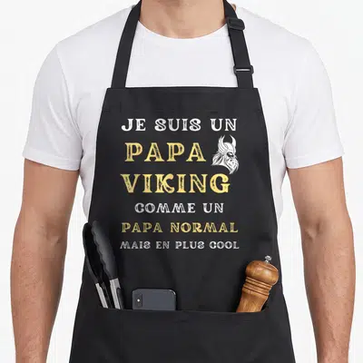 Tablier de cuisine noir avec inscription Je suis un papa viking comme un papa normal mais en plus cool et illustration de casque viking.