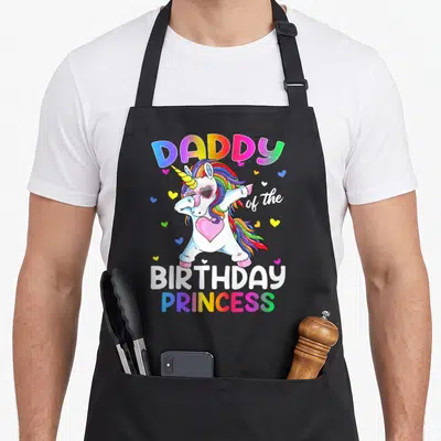 Tablier de cuisine noir avec une licorne aux couleurs vives et des coeurs flottants autour d'elle.