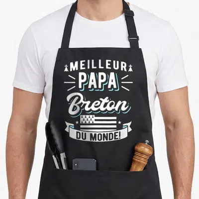 Tablier de cuisine noir avec inscription Meilleur Papa Breton Du Monde et drapeau breton stylisé en blanc et bleu.