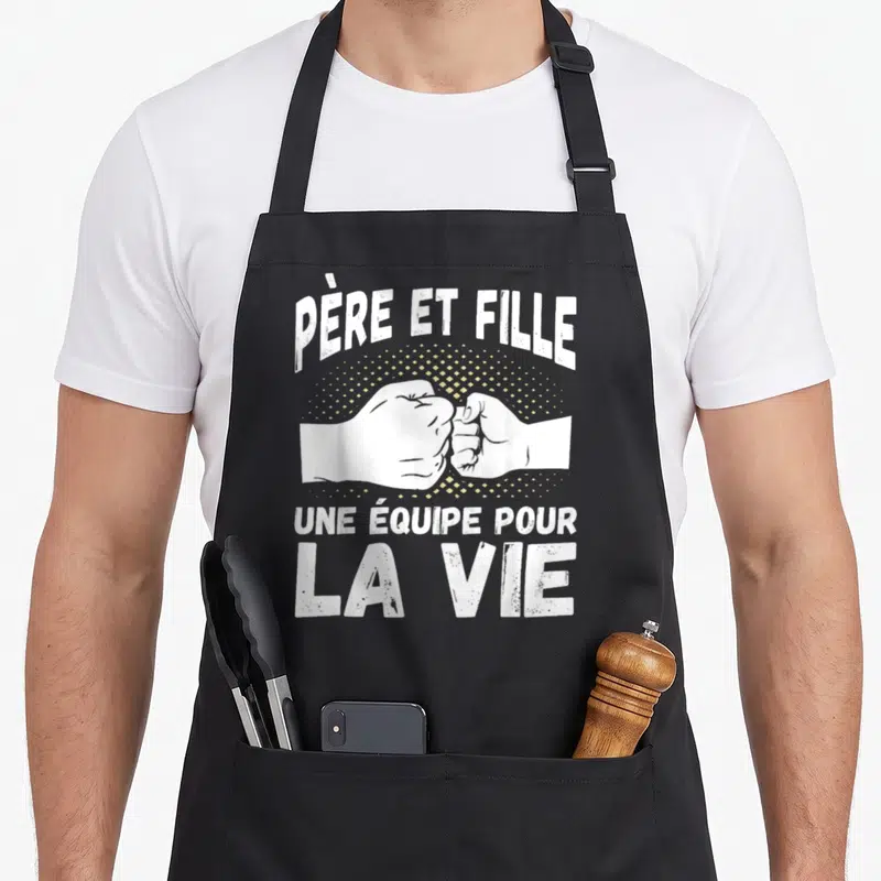 Tablier de cuisine noir avec inscription « Père et Fille Une Équipe Pour La Vie » et deux poings s'affrontant amicalement.