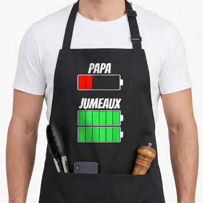 Tablier de cuisine noir avec icônes de batteries Papa et Jumeaux en rouge et vert.