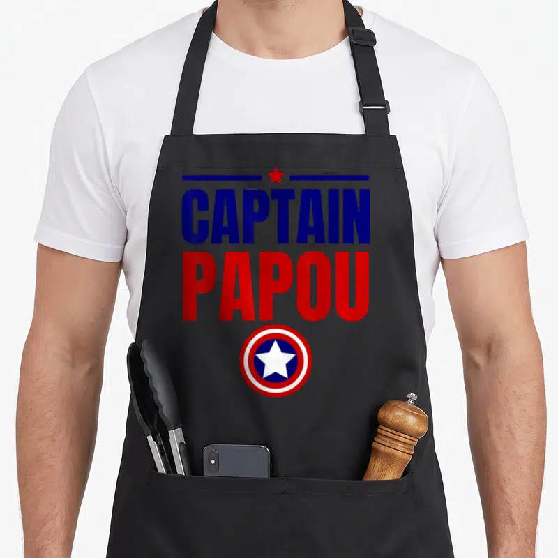 Tablier de cuisine noir avec l'inscription Captain Papou et un logo circulaire étoilé.