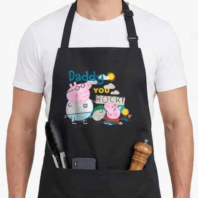 Tablier de cuisine noir avec Daddy Pig, Peppa et l'inscription Daddy You Rock en couleurs vives.