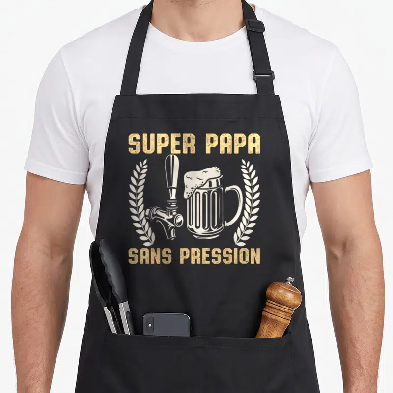 Tablier de cuisine noir avec inscription Super Papa Sans Pression Bière Apéro et illustration de robinet de bière encadré de lauriers.