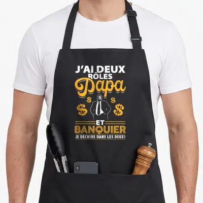 Tablier de cuisine noir avec illustration d'un homme en costume et symboles dollar orange.