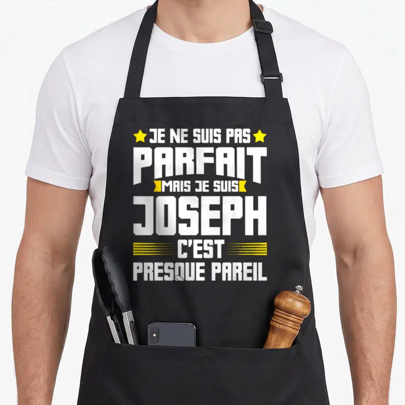 Tablier de cuisine noir avec le texte blanc et jaune Je ne suis pas parfait mais je suis Joseph c'est presque pareil.