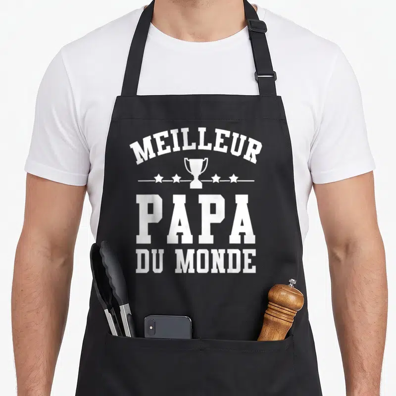 Tablier de cuisine noir avec inscription blanc Meilleur Papa du Monde et illustration de trophée.