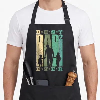 Tablier de cuisine noir avec typographie Best Dad Ever et silhouettes d'un père et de deux enfants.