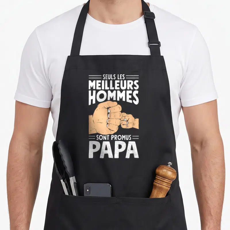Tablier de cuisine noir avec inscription Seuls les meilleurs hommes sont promus papa et deux poings qui se touchent.