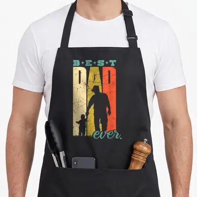 Tablier de cuisine noir avec Best Dad Ever et silhouettes père fils style rétro coloré.