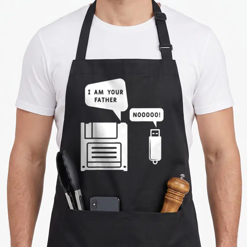 Tablier de cuisine noir avec illustration d'une disquette et d'une clé USB en blanc sur fond uni.