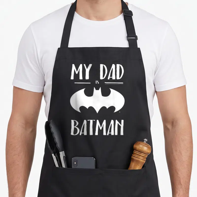 Tablier de cuisine noir avec inscription blanche My Dad Is Batman et logo édenté central.