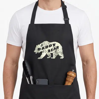 Tablier de cuisine noir avec silhouette d'ours beige et texte « DADDY BEAR » en typographie usée.