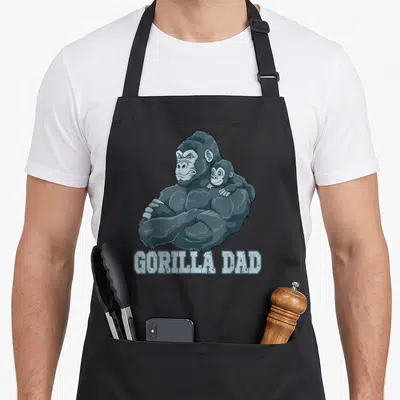 Tablier de cuisine noir avec illustration d'un gorille musclé portant un bébé sur l'épaule et le texte GORILLA DAD.