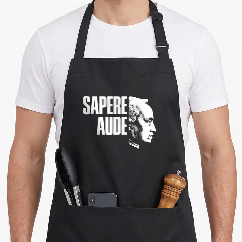 Tablier de cuisine noir avec portrait blanc d'Immanuel Kant et texte Sapere Aude en typographie bold.