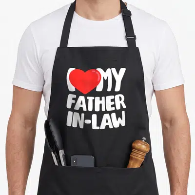 Tablier de cuisine noir avec texte blanc et cœur rouge exprimant l'affection pour le beau-père.
