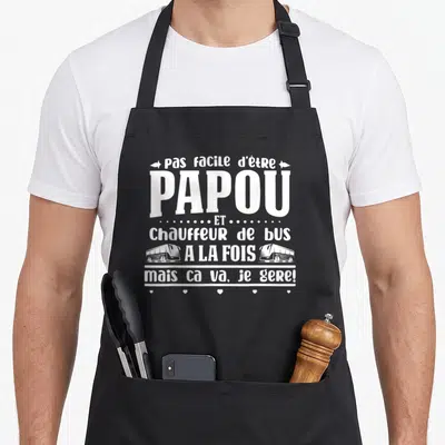 Tablier de cuisine noir avec inscription Papou chauffeur de bus à la fois mais ça va je gère en blanc.