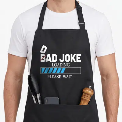Tablier de cuisine noir avec texte Bad Joke Loading et barre de progression bleue.