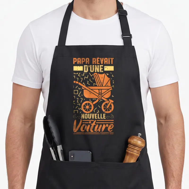 Tablier de cuisine noir avec une illustration orange d'une poussette vintage et du texte « Papa rêvait d'une nouvelle voiture ».