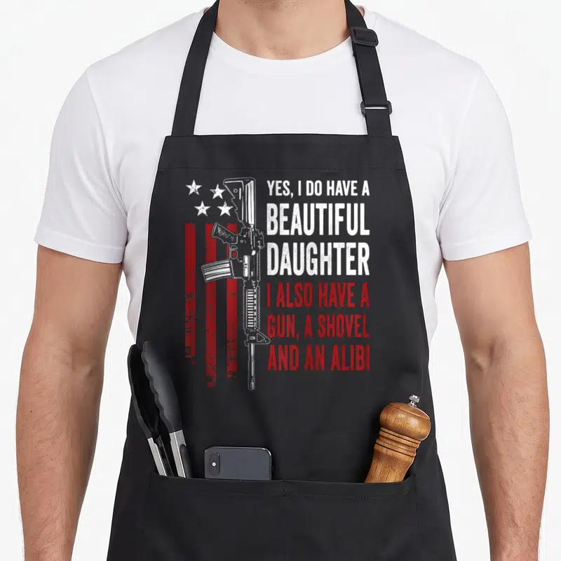 Tablier de cuisine noir avec illustration de fusil et texte « Yes I do have a {beautiful} daughter » sur fond de drapeau USA.