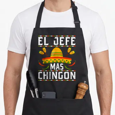 Tablier de cuisine noir avec un sombrero jaune, des maracas et le texte El Jefe Mas Chingon en lettres blanches.