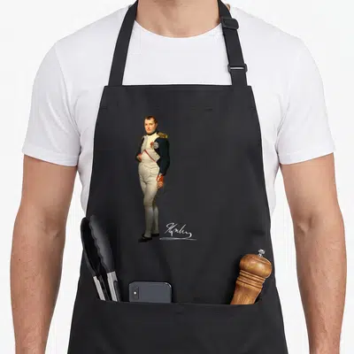 Tablier de cuisine noir avec illustration de Napoléon Bonaparte en uniforme impérial et signature stylisée en bas à droite.