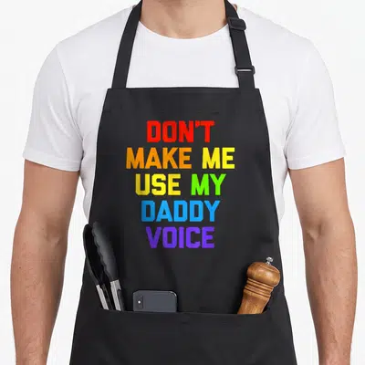 Tablier de cuisine noir avec inscription Don't Make Me Use My Daddy Voice en lettres multicolores rainbow.